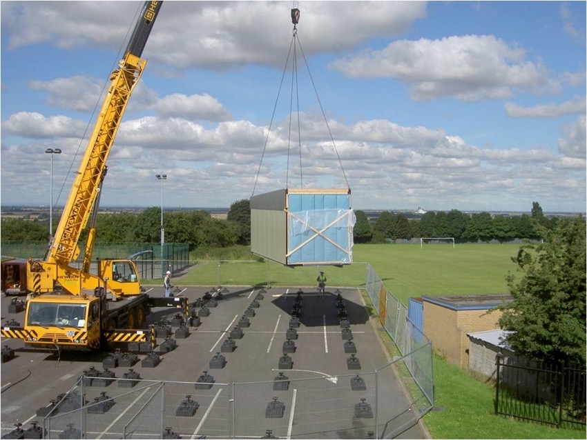 a modular build being lifed by crane on to foundation pads